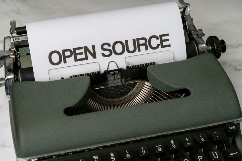 Feuille portant les mots « Open source » dans une machine à écrire